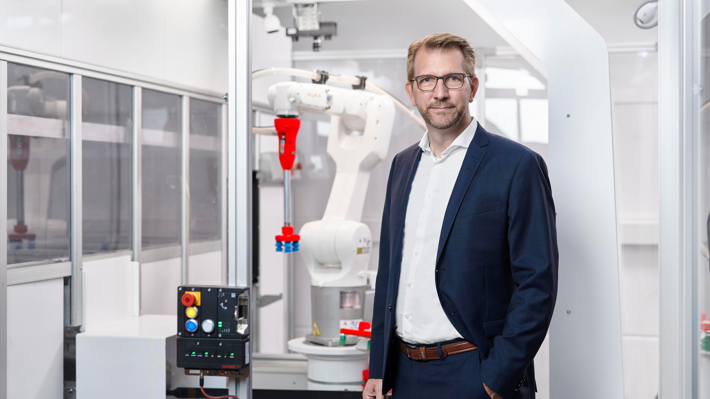 Swisslog CEO Jens Schmale next to AI based item picking robot ItemPiQ